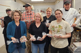 Participants proudly holding their handmade chocolate truffles after completing a hands-on truffle-making workshop at The Secret Chocolatier in Charlotte, NC, led by Chef Bill Dietz.
