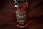Cloister Honey Infused Bourbon Honey bottle with a brown label, on burgundy fabric.