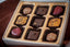 Fan Favorites 2020 9-piece chocolate box — assortment including strawberry-shaped bonbons, gold-patterned dark chocolate squares, and nut-topped pieces.