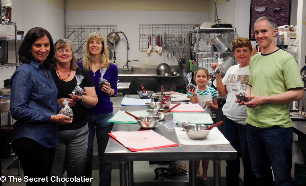 Families and friends proudly holding handmade chocolate bark at The Secret Chocolatier’s hands-on workshop in Charlotte, NC—fun for all ages and skill levels