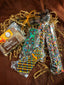 Father's Day gift assortment — Milk Chocolate Hazelnut Butter Toffee, chocolate-covered pretzel sticks with rainbow sprinkles, and chocolate tie cookies on crinkle paper.