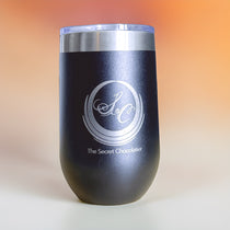 Black stainless steel insulated tumbler with clear lid, etched with The Secret Chocolatier monogram and brand name.