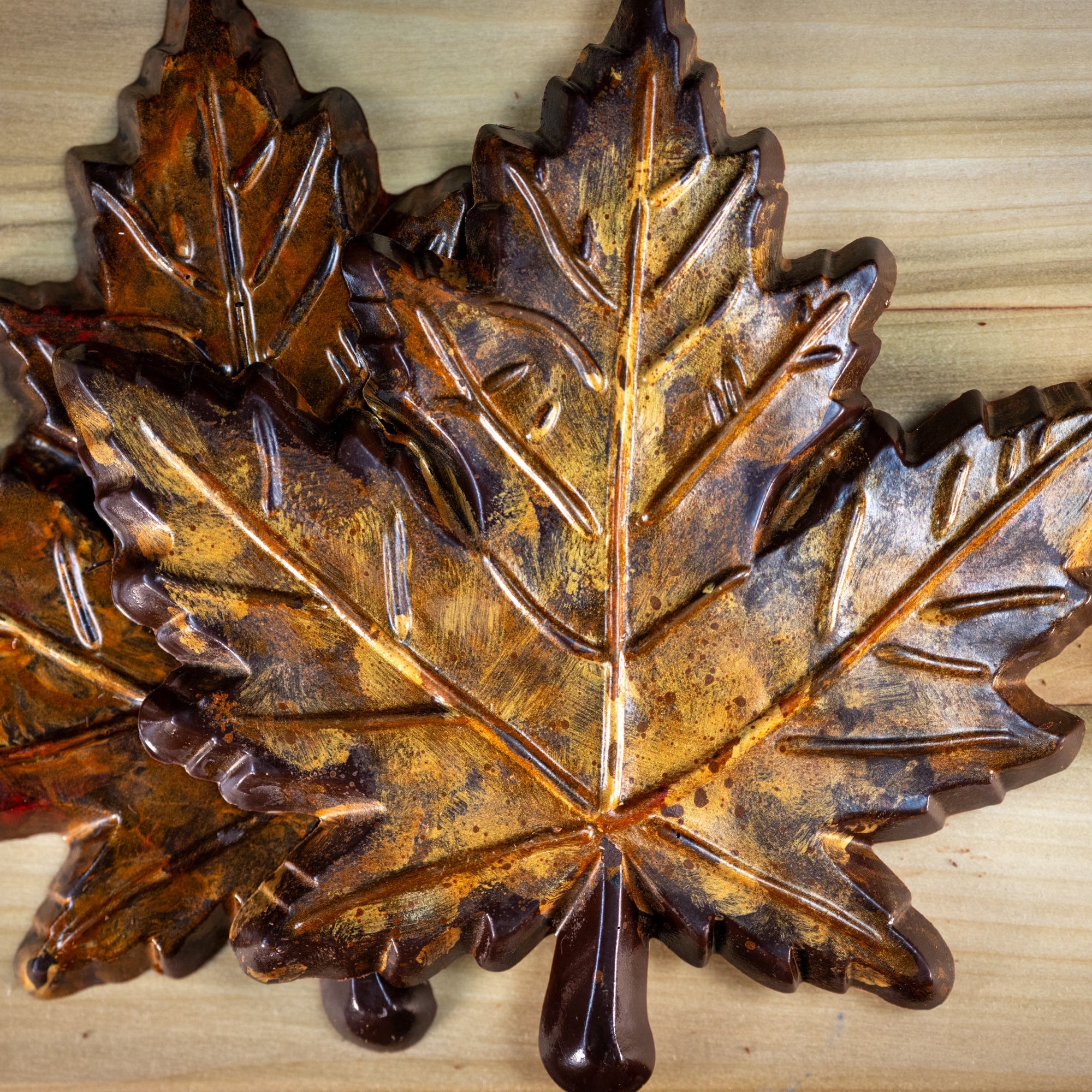 A dark chocolate maple leaf colored with autumn gold and orange colors. Rustic looking, edible. 