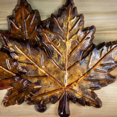 A dark chocolate maple leaf colored with autumn gold and orange colors. Rustic looking, edible. 