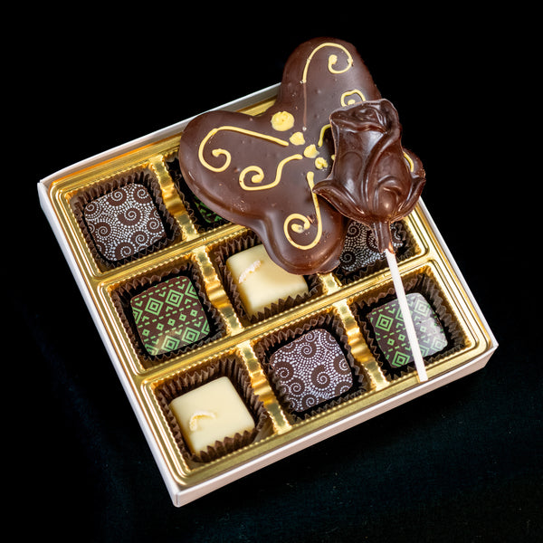 Mother's Day chocolate assortment — ornate gift box with a gold-filigree chocolate butterfly, a chocolate rose pop, and six patterned bonbons.
