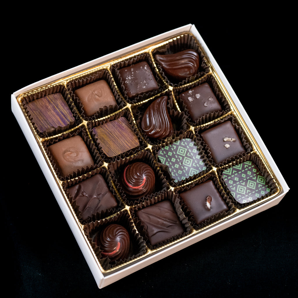 Mother's Day 16-piece chocolate box — elegant assortment of bonbons in dark, milk, and white chocolate with subtle textured tops and decorative patterns.