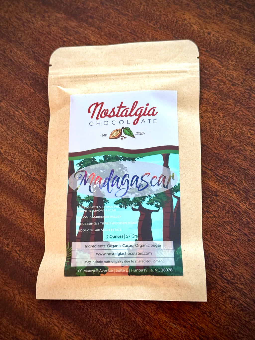 Nostalgia Chocolate Madagascar single-origin bar in a kraft-paper bag with a green forest-illustration label.