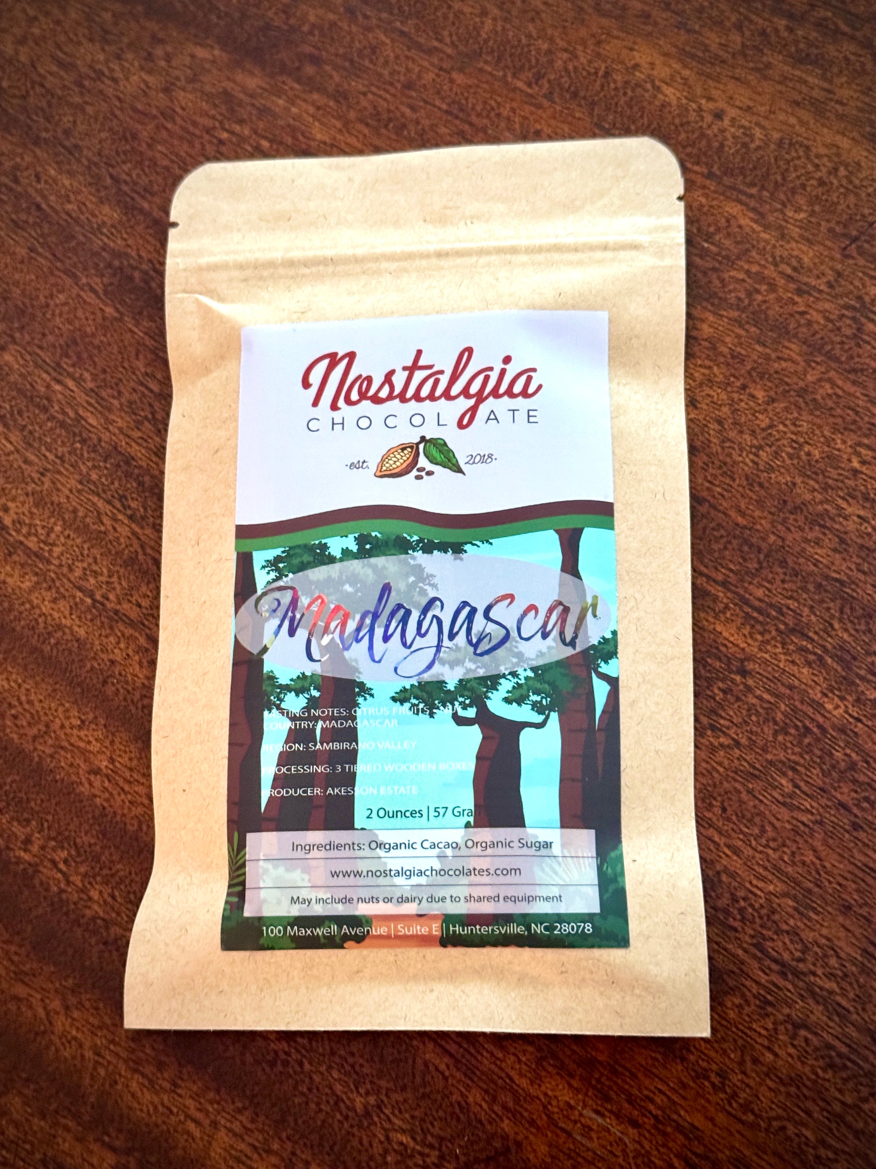 Nostalgia Chocolate Madagascar single-origin bar in a kraft-paper bag with a green forest-illustration label.