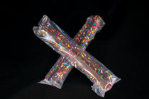 Two cellophane-wrapped Chocolate Pretzel Sticks finished with rainbow sprinkles, crossed on a dark background.