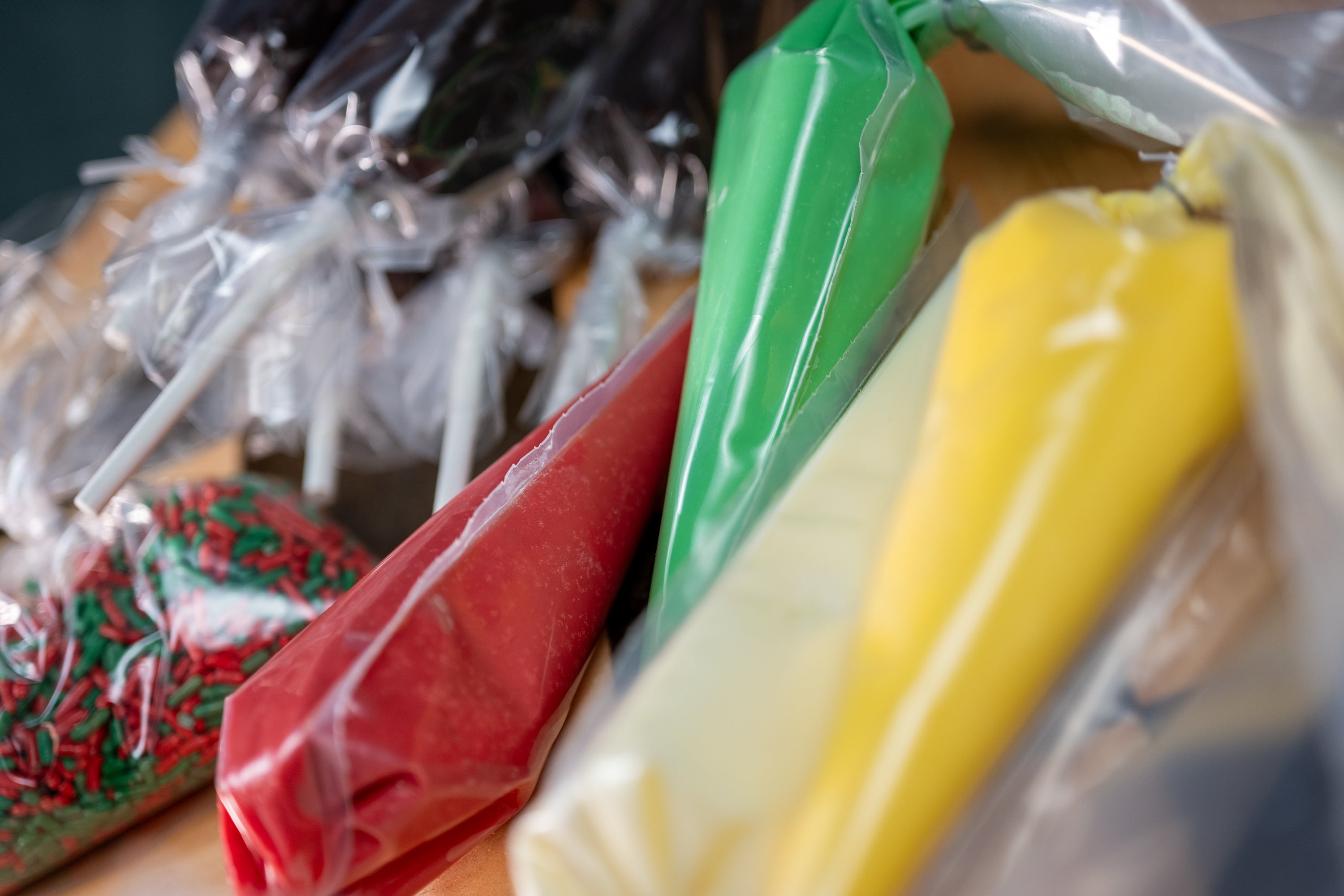 Brownie Pop Decorating Kit Christmas piping bags — close-up of green, red, and yellow icing bags with Christmas sprinkles.