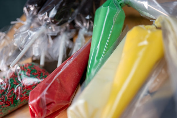 Brownie Pop Decorating Kit Christmas piping bags — close-up of green, red, and yellow icing bags with Christmas sprinkles.