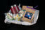 The Cozy Cocoa Collection gift basket — pink Secret Chocolatier tumbler, Hot Cocoa Dreams pouch, peppermint truffle ball, and hand-piped snowman and angel chocolates.
