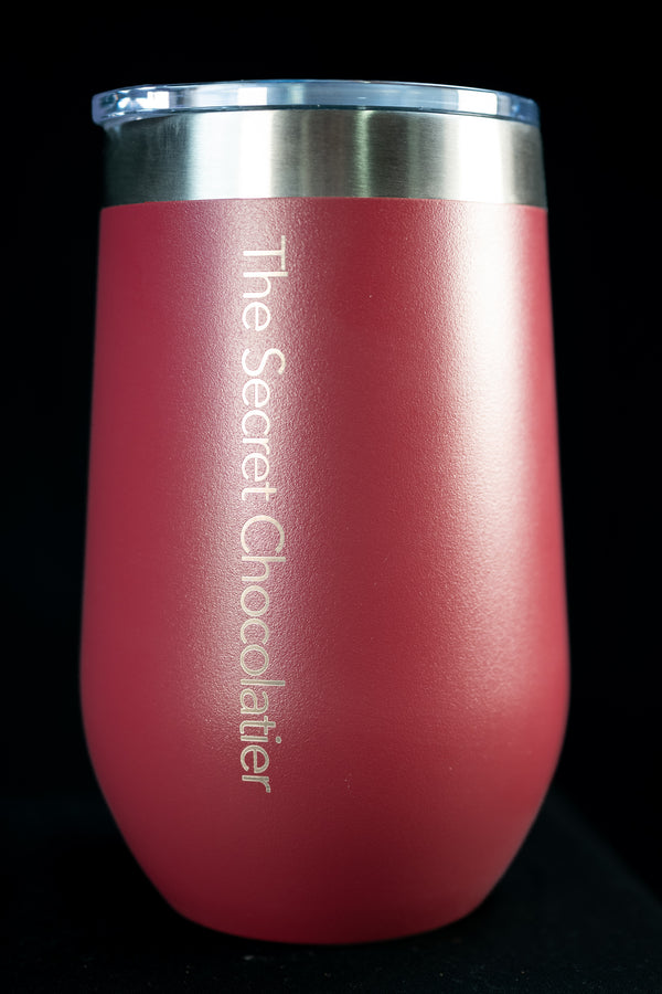 Pink stainless steel tumbler engraved with 'The Secret Chocolatier' vertically on the side.