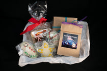 Cozy Cocoa Collection basket — Seasonal World's Best Peppermint Chocolate Bar tied with a red ribbon, Hot Cocoa Dreams pouch, peppermint truffle ball, and hand-piped snowman and angel chocolates.