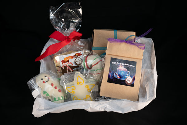 Cozy Cocoa Collection basket — Seasonal World's Best Peppermint Chocolate Bar tied with a red ribbon, Hot Cocoa Dreams pouch, peppermint truffle ball, and hand-piped snowman and angel chocolates.