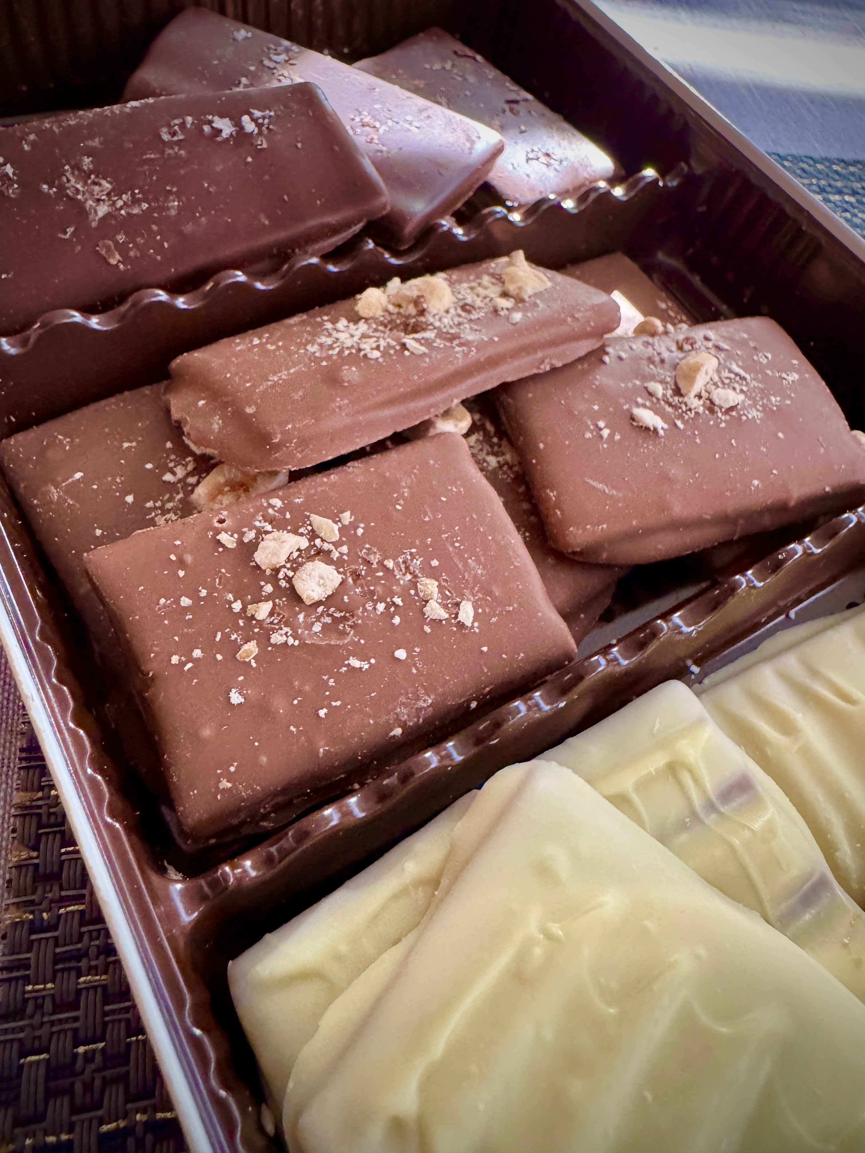 Toffee Sampler Gift Set with milk chocolate toffees and white chocolate honey toffees stacked together in the box. Main image