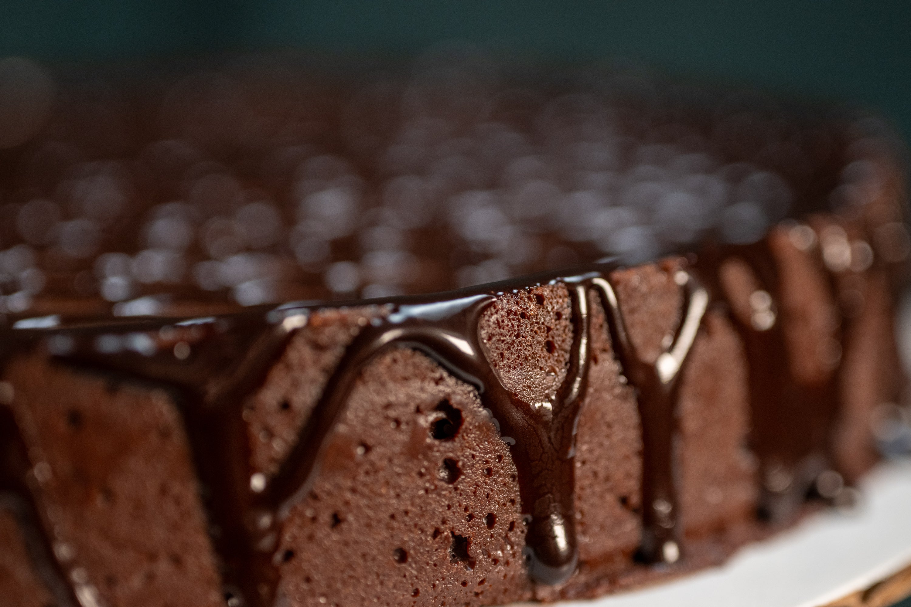 Side view of the Chocolate Oblivion Torte — dense chocolate cake with ganache poured over the top and dripping down the sides.
