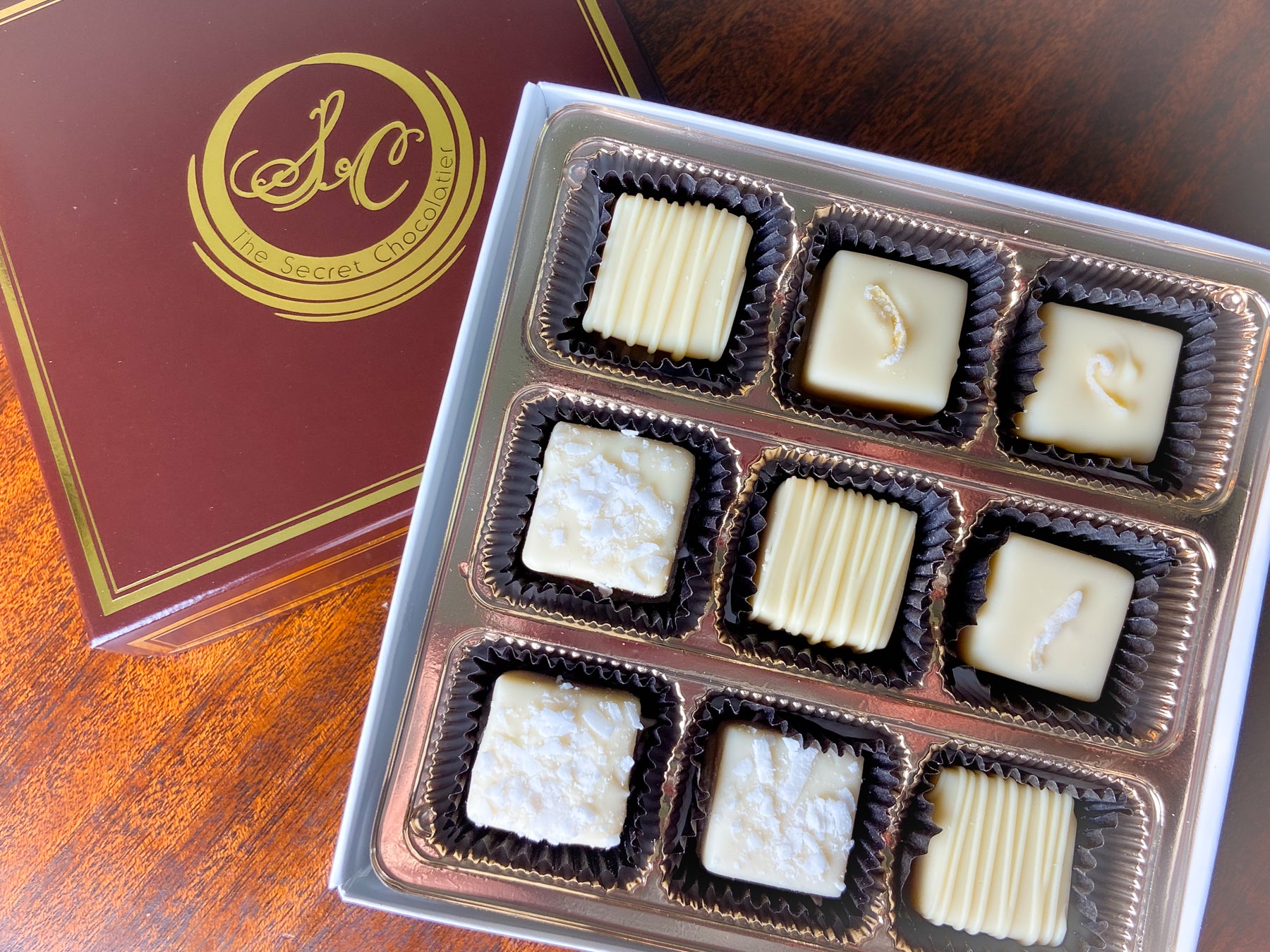 All About the White Chocolate 9-piece box — assortment of white chocolate truffles and bonbons with varied decorative pipings. Main image