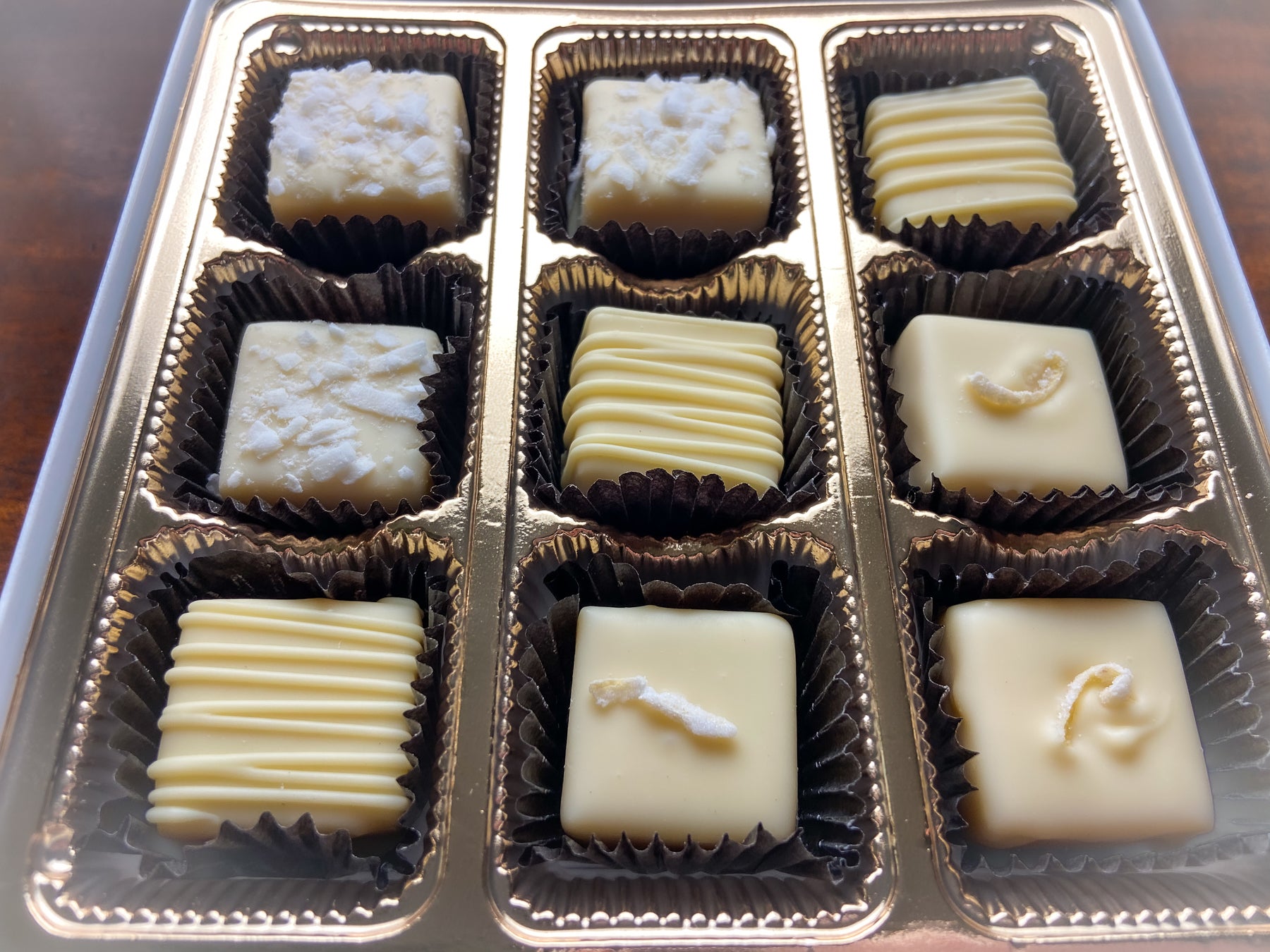Close-up of the All About the White Chocolate assortment, white chocolate pieces with piped decorations on each.