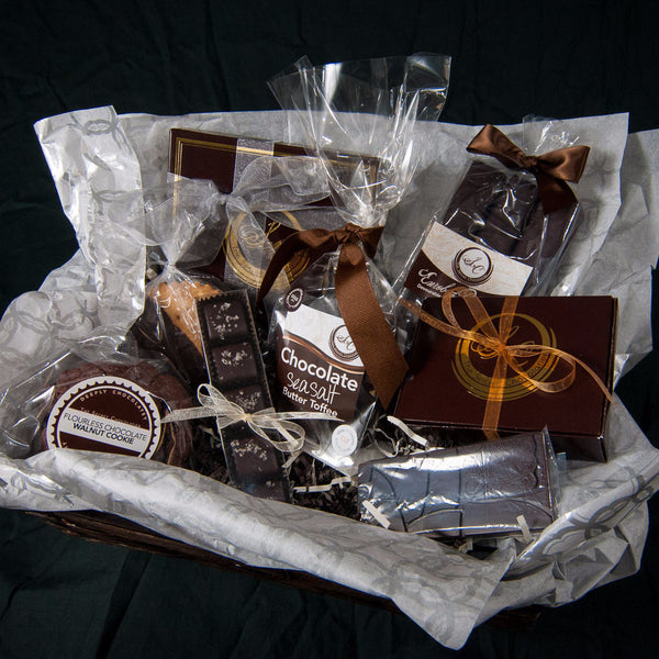 Overhead view of the Executive Chocolate Box gift basket, cellophane-wrapped TSC chocolates and confections tied with ribbons.