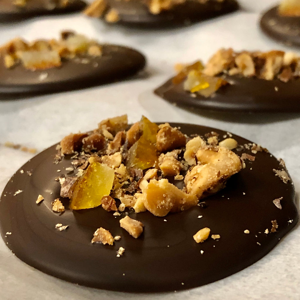 Walnut Orange Dark Chocolate Mendiant — round dark chocolate discs topped with chopped walnuts and candied orange peel.