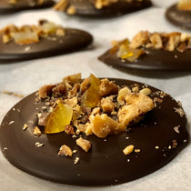 Walnut Orange Dark Chocolate Mendiant — round dark chocolate discs topped with chopped walnuts and candied orange peel.