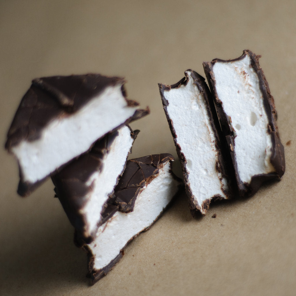 Chocolate Marshmallows arranged together, the chocolate coating in detail on each piece.
