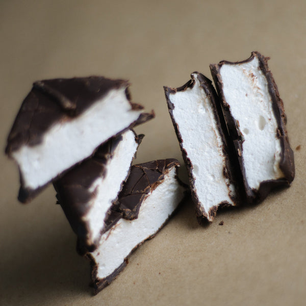 Chocolate Marshmallows arranged together, the chocolate coating in detail on each piece.