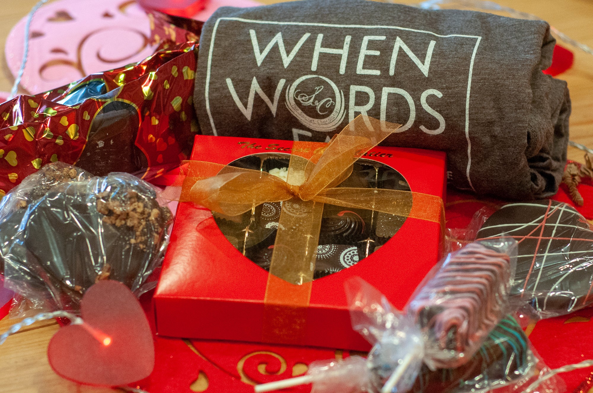 When Words Fail There's Always Chocolate gift basket — TSC shirt with 'WHEN WORDS FAIL' design, red heart-window box of truffles, chocolate-covered pretzel sticks, and heart-shaped chocolate pops. Main image