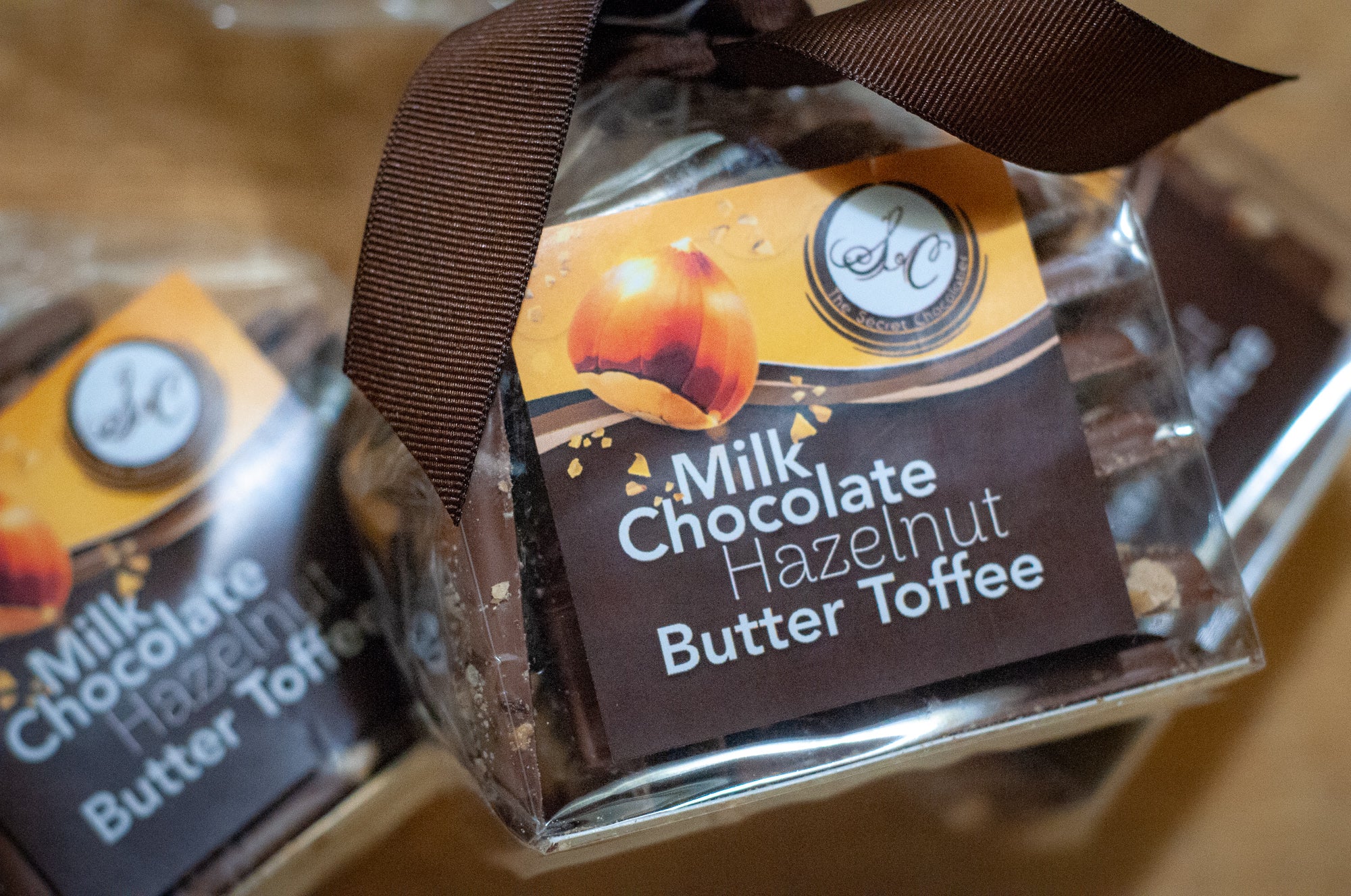 Stack of Milk Chocolate Hazelnut Butter Toffee pieces showing the toffee layer beneath the hazelnut-topped milk chocolate.
