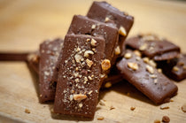 Close-up of Milk Chocolate Hazelnut Butter Toffee, the buttery toffee texture visible beneath the chopped-hazelnut milk chocolate top.