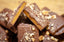 Milk Chocolate Hazelnut Butter Toffee broken into rough pieces with chopped hazelnuts across the milk chocolate.