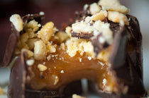 Peanut Caramel Cup cross-section showing the caramel filling inside the chocolate cup, topped with crushed peanuts.