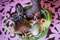 Small Chocolate Easter Basket from above — chocolate butterfly, milk and dark chocolate bunnies, and a hand-decorated egg in a green-edged basket.