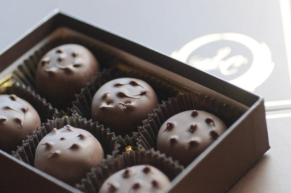 Peanut Butter Porcupines arranged in paper cups, each dome a dark chocolate shell around peanut butter filling.