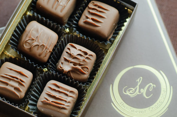 Milk Chocolate Truffles in a 6-piece box, each square truffle decorated with a caramel-colored ganache pattern.