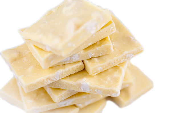 Stack of White Chocolate Toasted Macadamia Bark squares with macadamia nut pieces visible throughout the white chocolate.