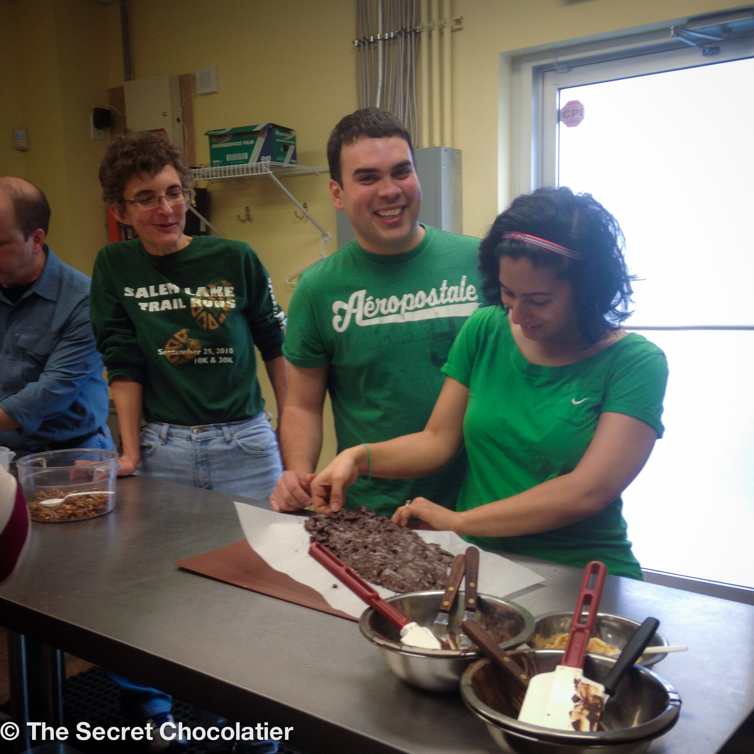 Participants creating chocolate bark at The Secret Chocolatier’s hands-on workshop in Charlotte, NC, enjoying a fun and interactive chocolate-making experience.