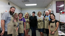 Participants posing after a chocolate truffle-making workshop at The Secret Chocolatier in Charlotte, NC, celebrating their hands-on chocolate experience.