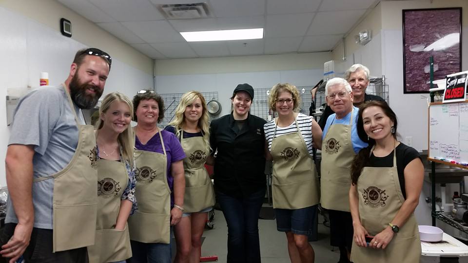 Participants posing after a chocolate truffle-making workshop at The Secret Chocolatier in Charlotte, NC, celebrating their hands-on chocolate experience.