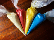 Brownie Pop Decorating Kit icing — cream, red, yellow, and blue piping bags ready for decorating.